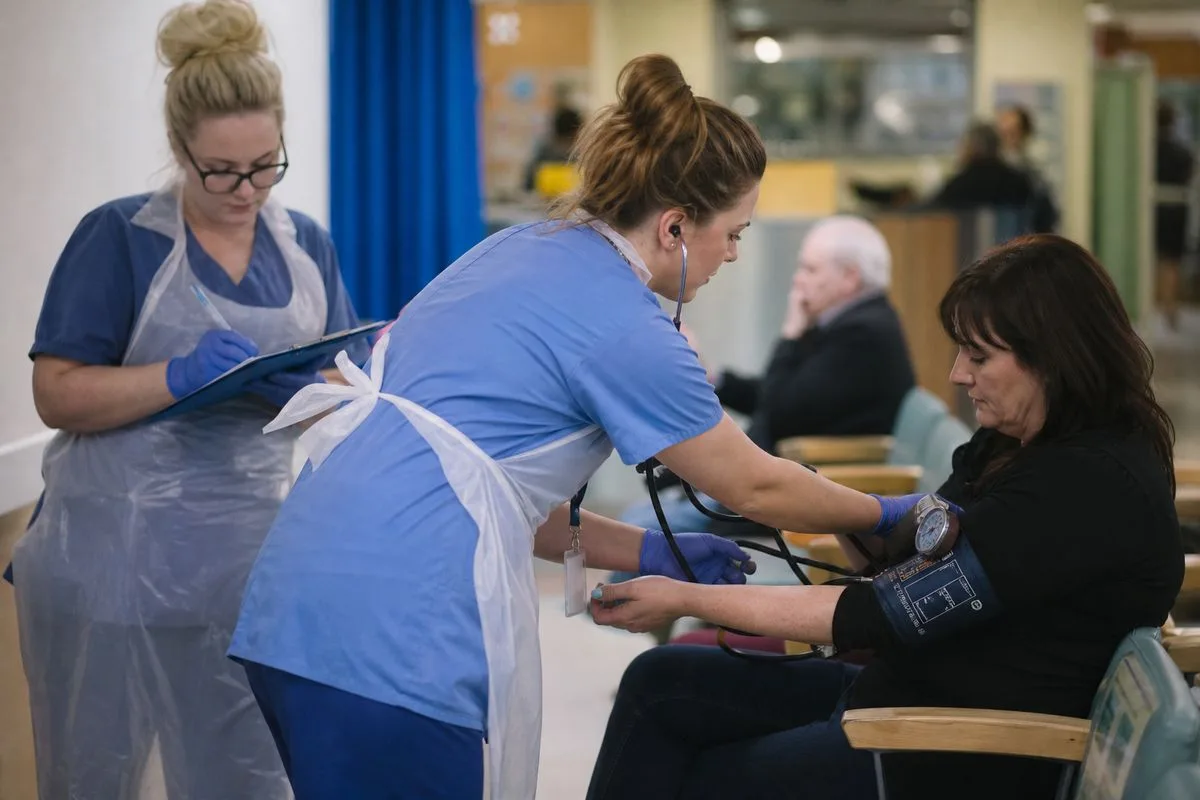 Nurses checking vital signs of a patient in A&E waiting room