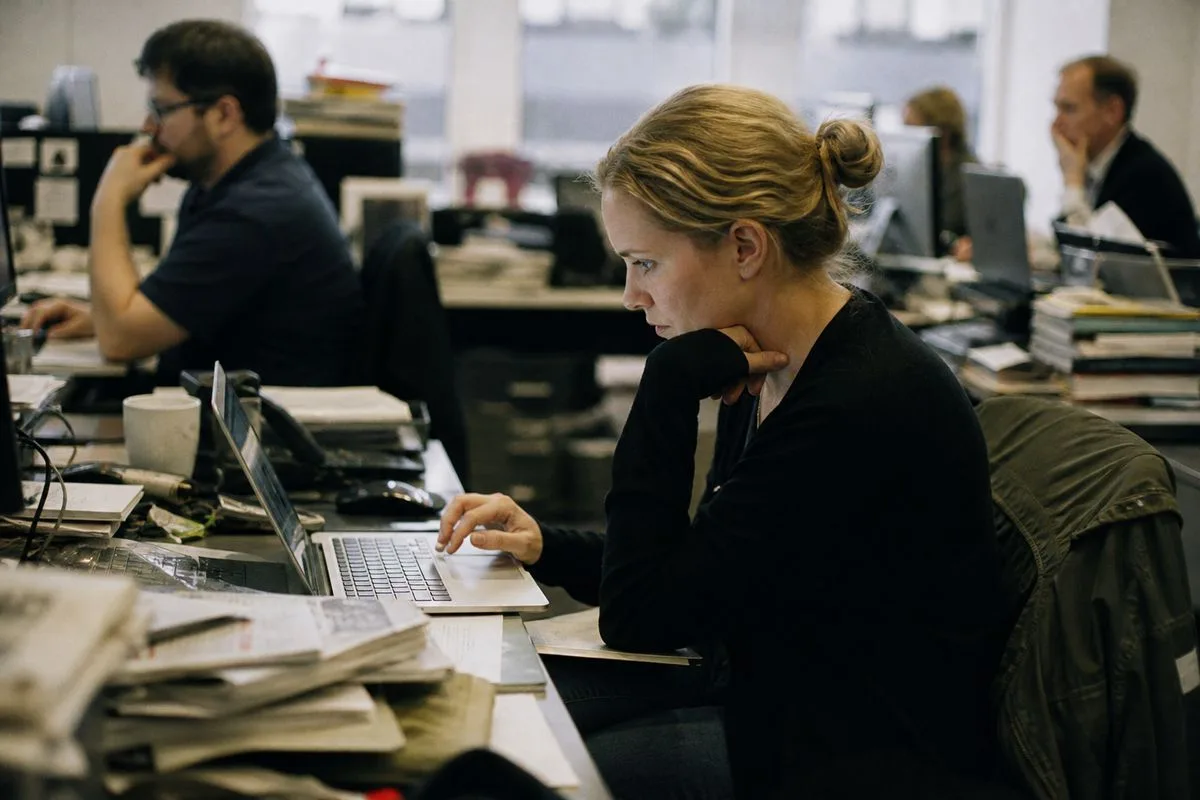 Journalists working on computers in a newsroom environment