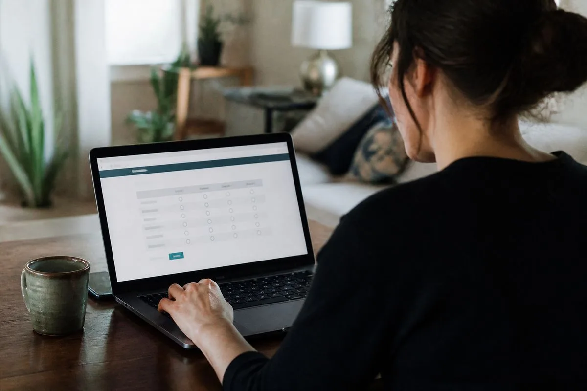 A person completing an online survey on a laptop at home