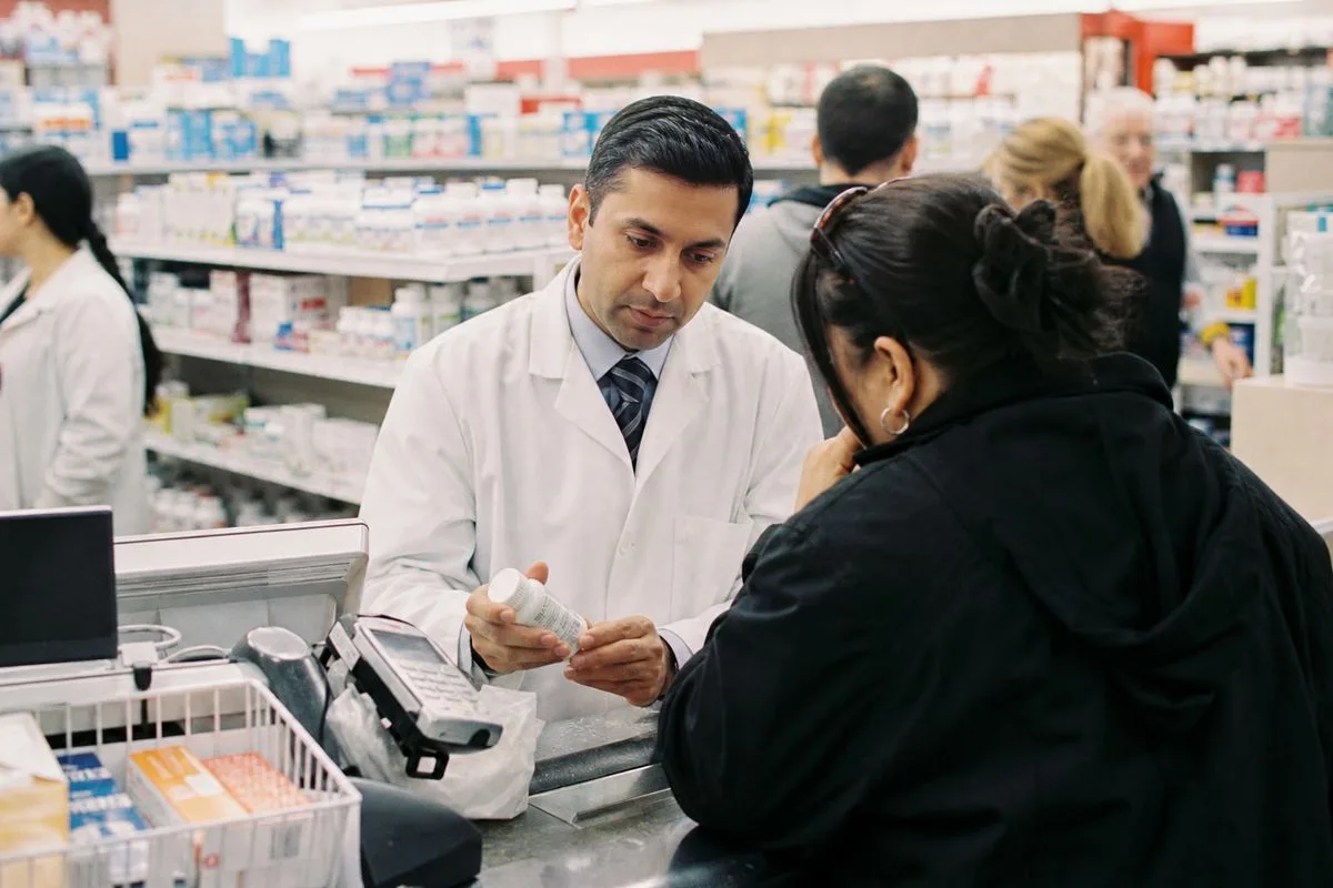 A pharmacist assisting a customer at a crowded CVS counter