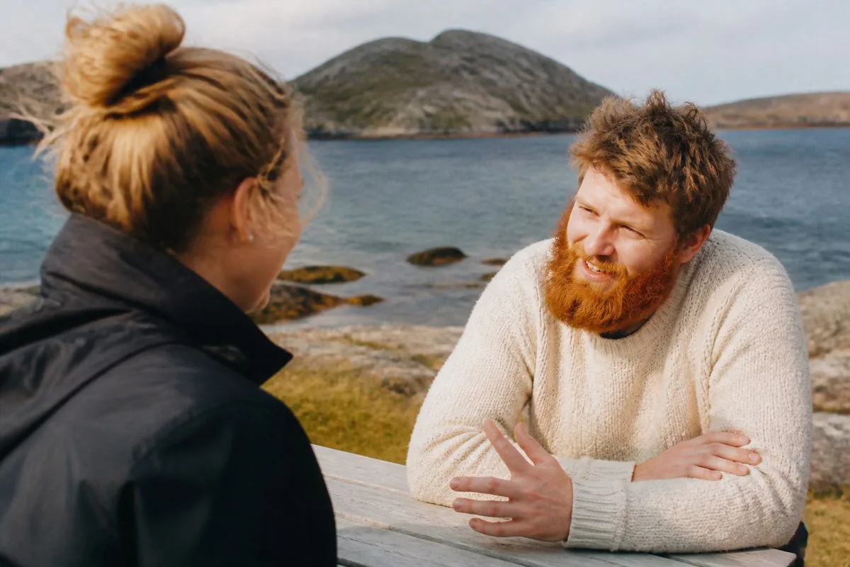 Two people engaged in a lively conversation outdoors in Newfoundland
