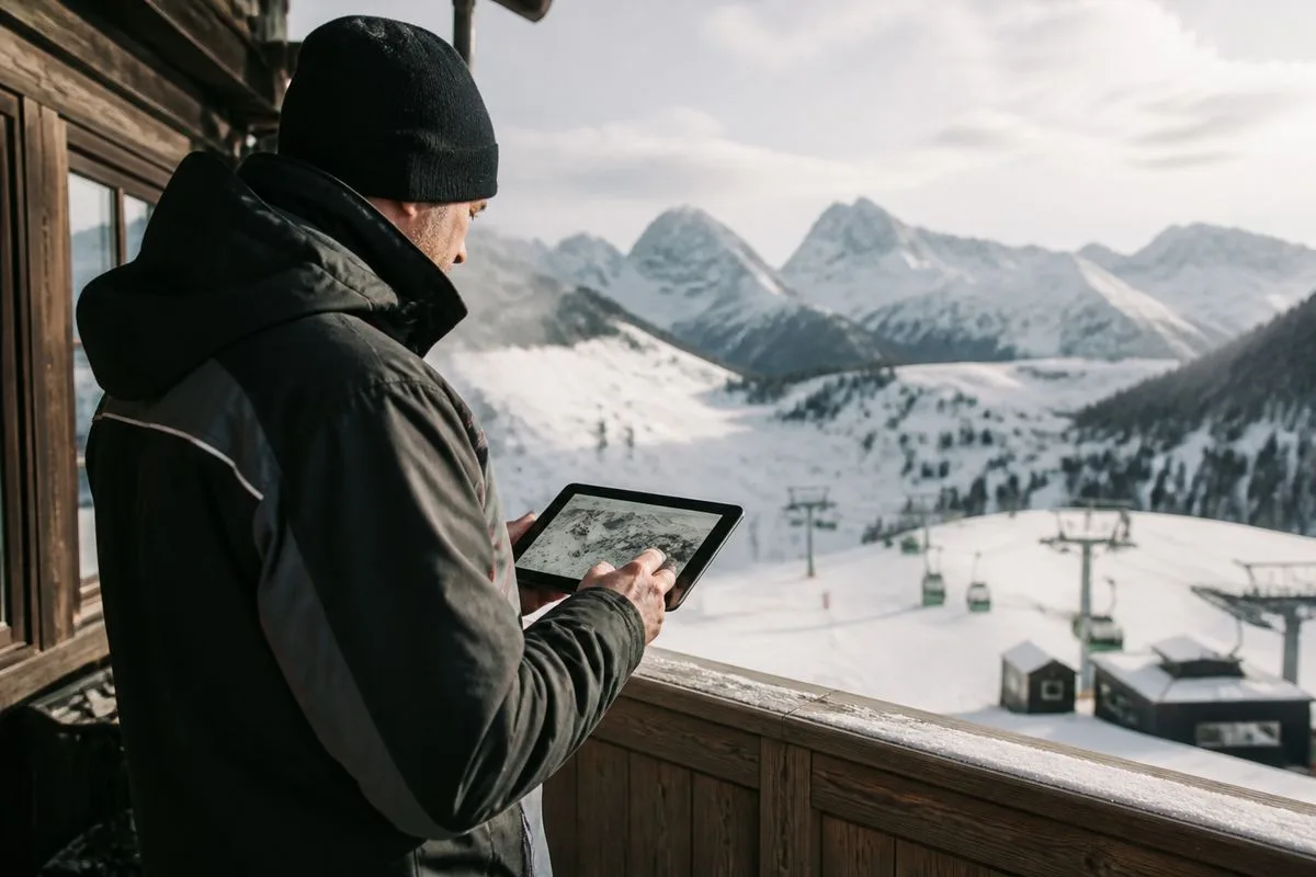 A ski resort employee checking live snow reports on a tablet.