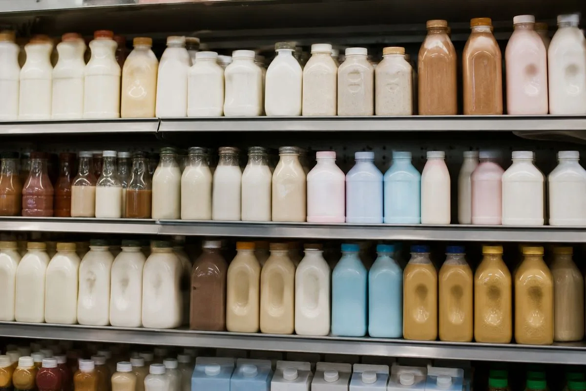 Shelves stocked with various dairy and plant-based creamers