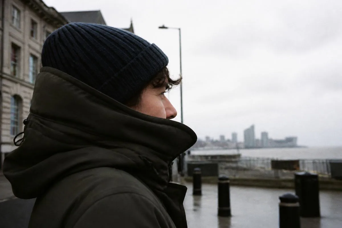 A person bundled up against a cold, windy Liverpool street.