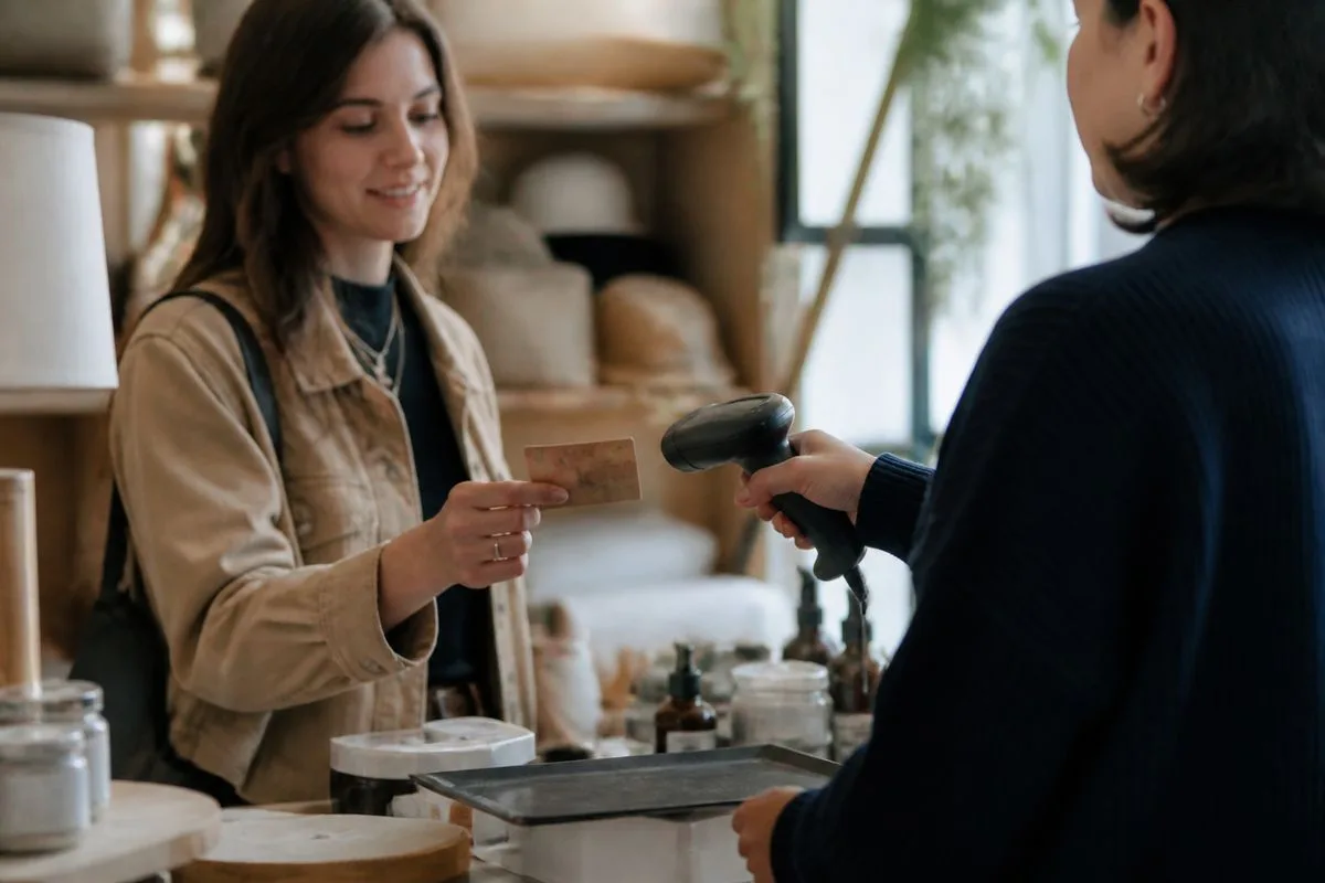 A customer scanning a gift card at a store checkout counter