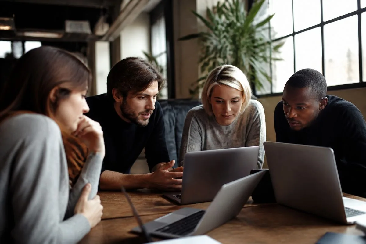 A team brainstorming around laptops in a modern office.