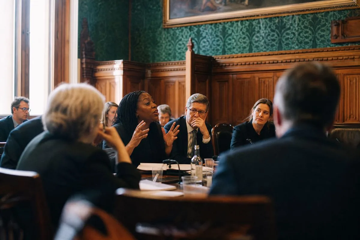 Councillors debating around a meeting table in a council chamber