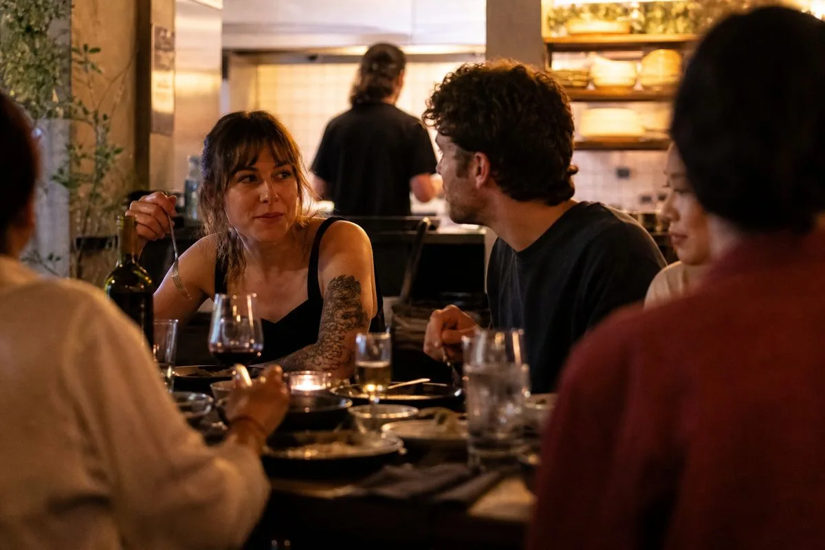 Customers dining at Side Hustle restaurant in evening light