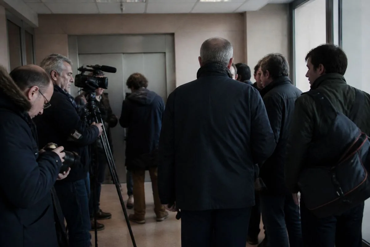 Journalists gathering outside a hospital waiting room
